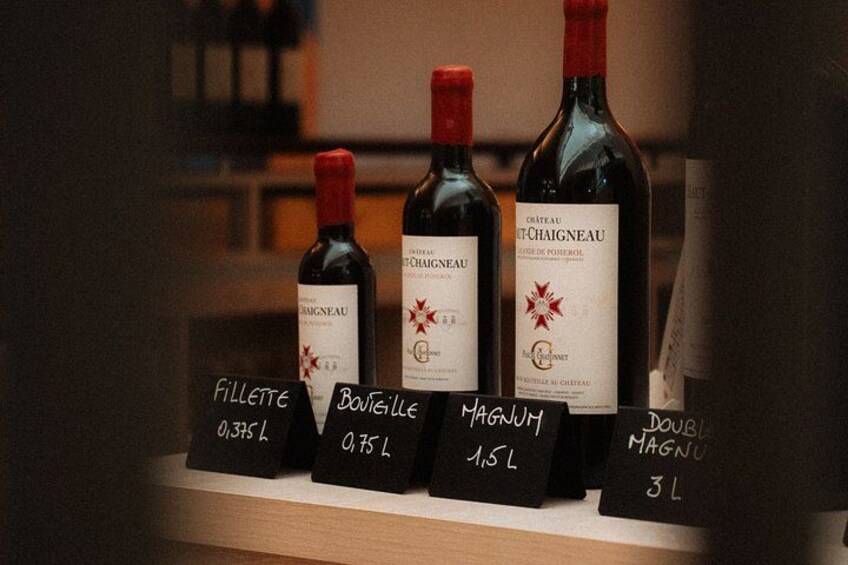 Botellas de vino con etiquetas e indicadores de volumen en una estantería. 5