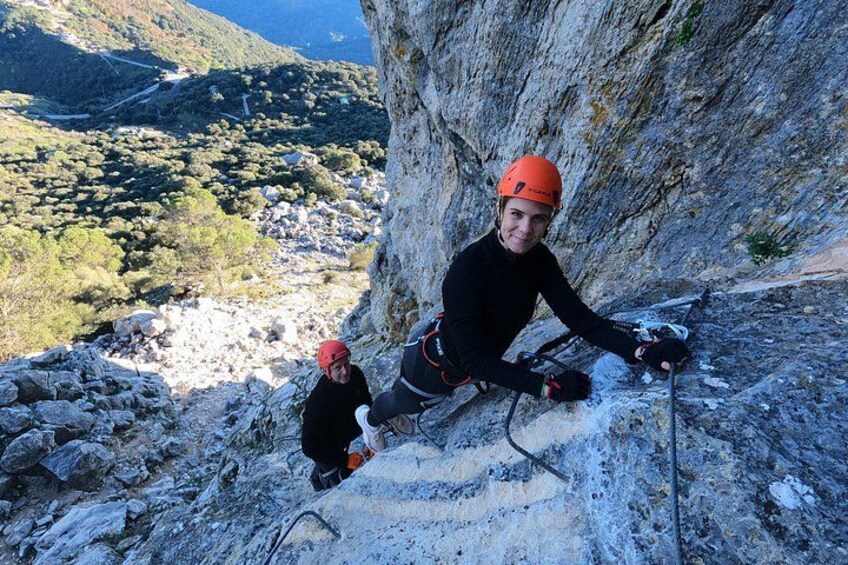 A person climbing a rocky mountain with a helmet and climbing gear. 5