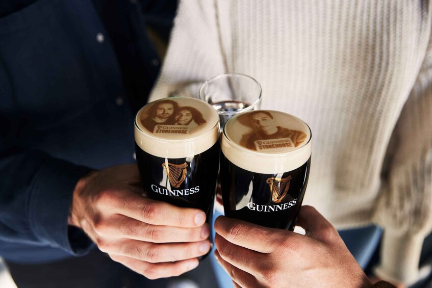 Due bicchieri di Guinness con una foto sul coperchio, tenuti da una persona vestita con una camicia blu. 4