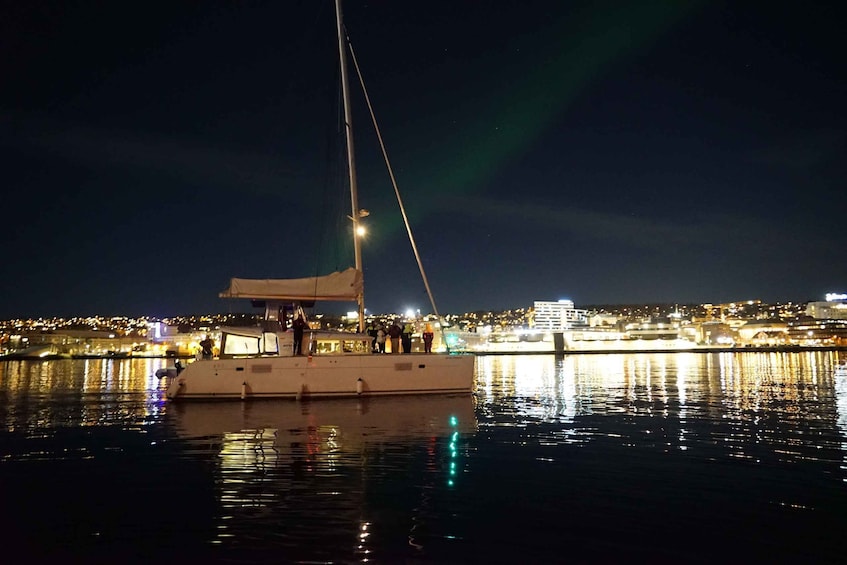 A sailboat docked at a harbor with a cityscape in the background. 5
