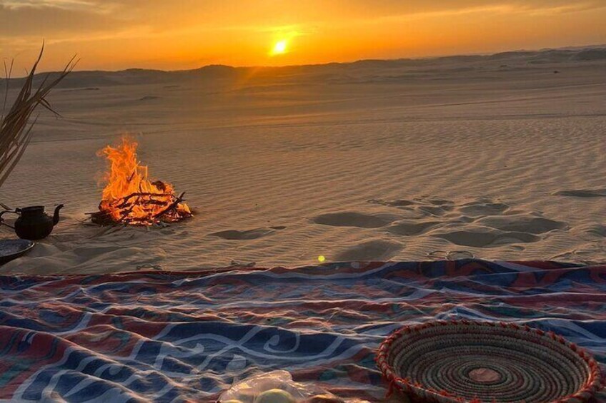 A desert landscape with a campfire, a woven basket, and a tea pot. 5
