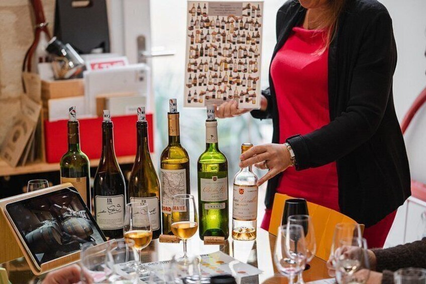 A wine tasting event with various bottles and glasses on a table. 3