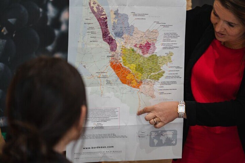 A person pointing at a map with various regions highlighted in different colors. 2