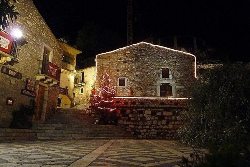 A stone building with a Christmas tree decorated with lights. 3