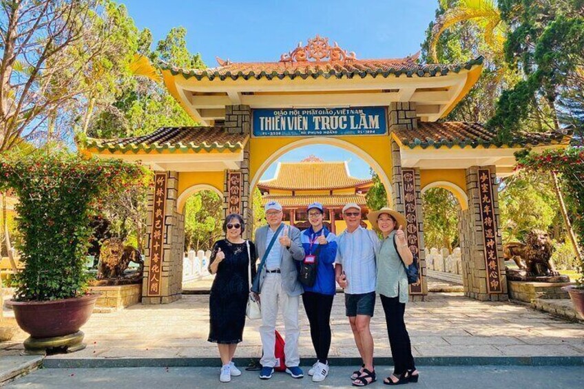 A group of people standing in front of a traditional gate with a sign that reads 'THIEN VUONG TROC LAM.' 5