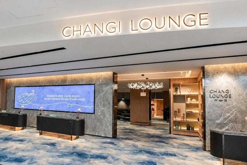 A lounge area with a sign reading 'CHANGI LOUNGE' and a television screen displaying a message. 2