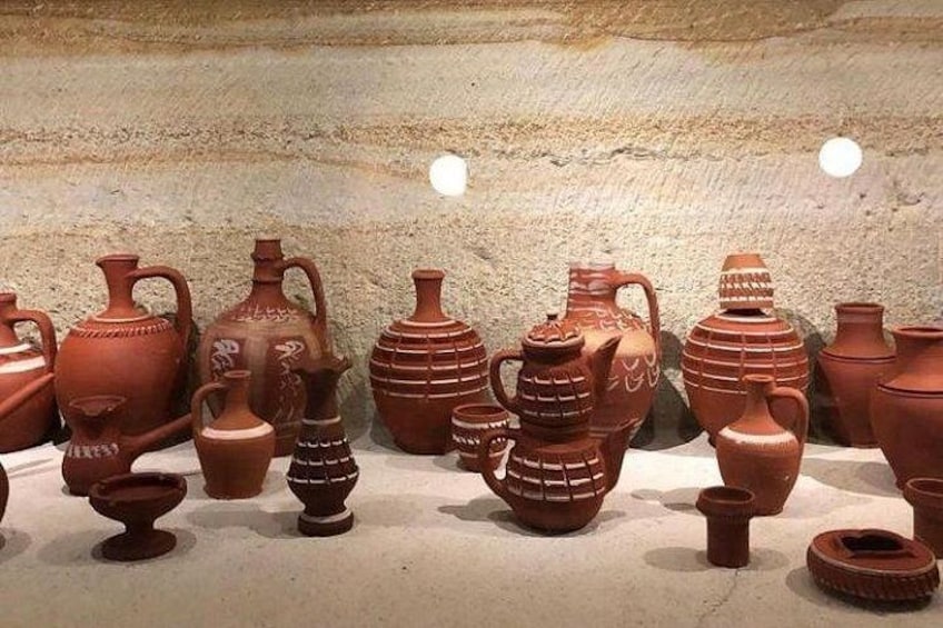 A collection of ancient pottery displayed on a stone floor. 2