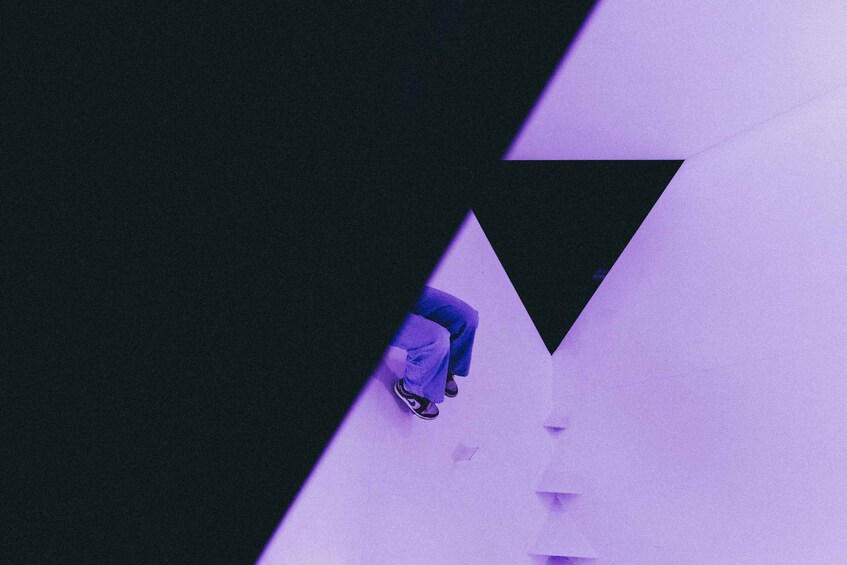 A person skateboarding on a ramp with geometric shapes in the background. 5