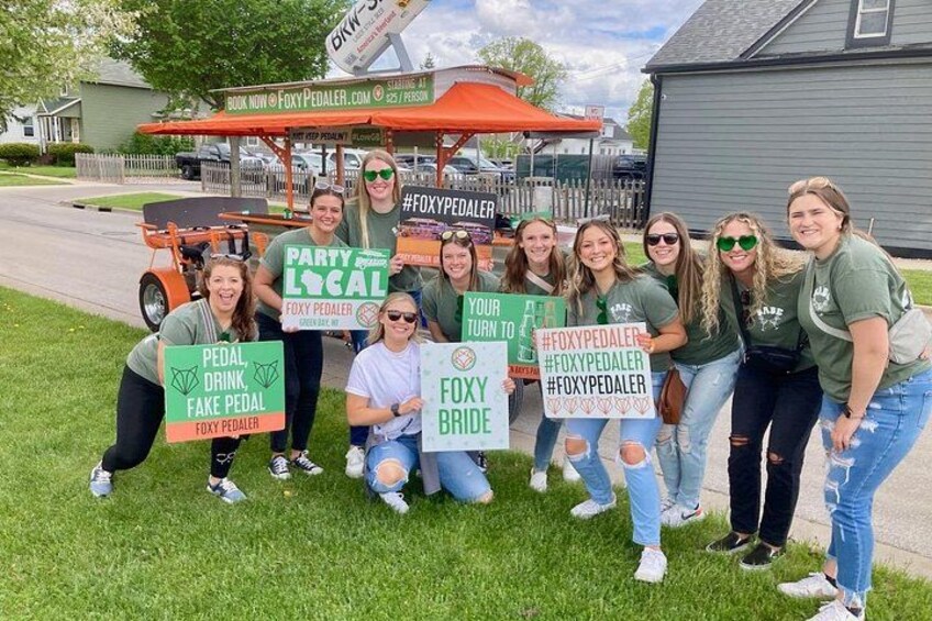 A group of people holding signs with messages, standing in front of a vehicle with a canopy. 1