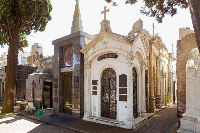 Un cementerio con lápidas ornamentales y una pequeña capilla. 4