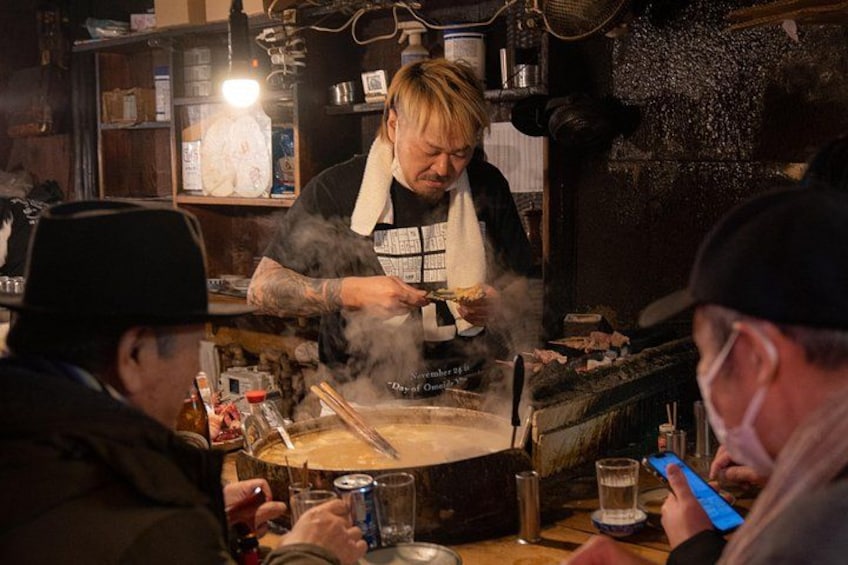 En person som lagar mat vid en spis, med ånga som stiger upp, omgiven av köksredskap och ingredienser. 5