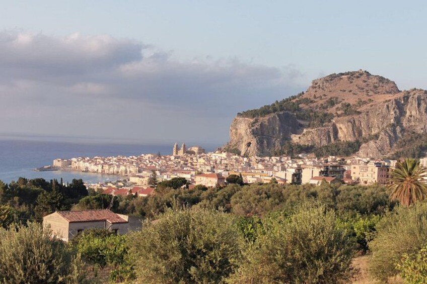 Una ciudad costera con una colina destacada, edificios densos y una vista despejada del mar. 4