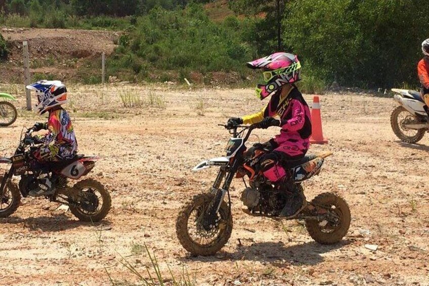 Two dirt bikes on a dirt track with cones. 4