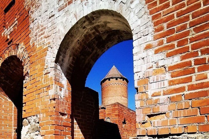 Eine Ziegelwand mit einem Bogen und einem Turm. 3