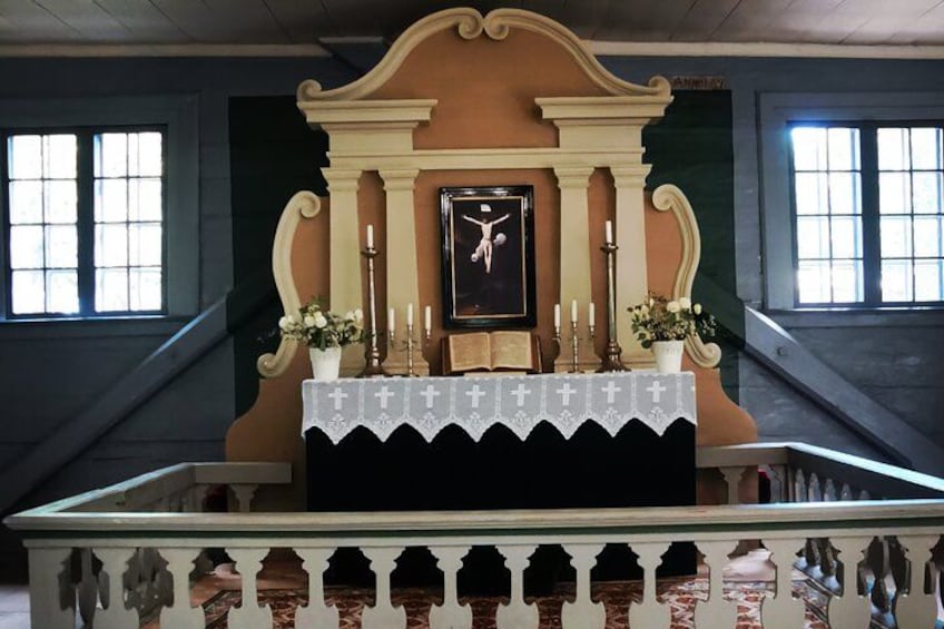 A church altar with a crucifix, candles, and flowers. 2