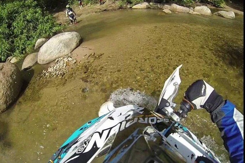 A kayak navigating a shallow water body with rocks and vegetation. 2