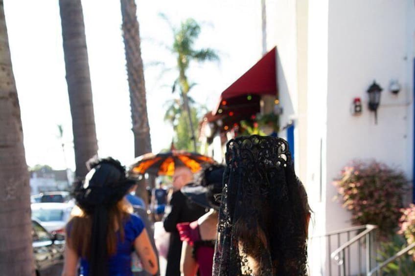 A street scene with palm trees, a red awning, and a black chair. 2