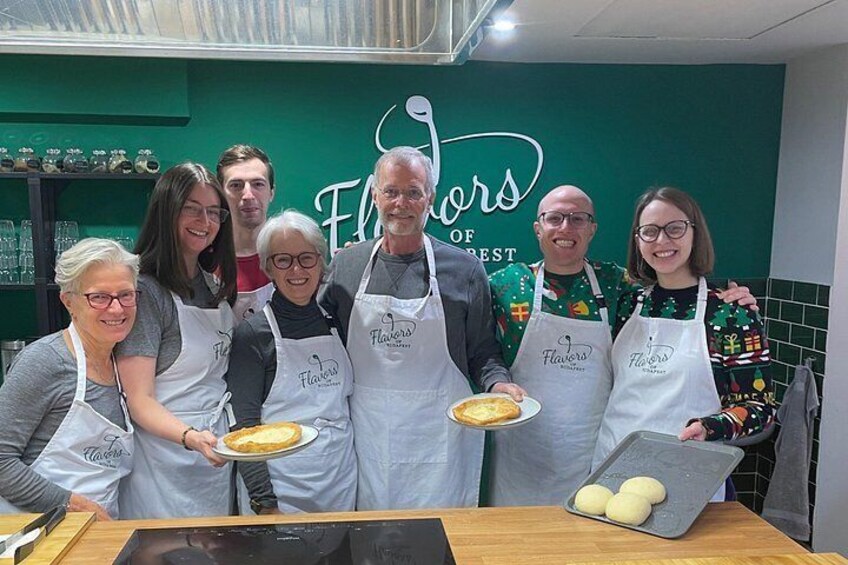 A group of people in aprons with a green wall and a sign that reads 'Flowers of Best.' 4