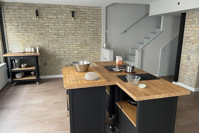 A kitchen with a wooden countertop, a metal bowl, a kettle, and a coffee maker. 2