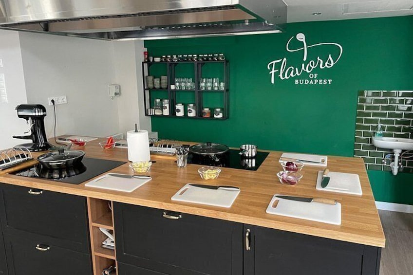 A kitchen with a green wall, a black countertop, and a sink. 3