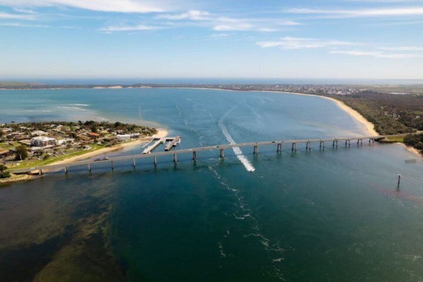 Un ponte costiero, una spiaggia e una città in lontananza. 4