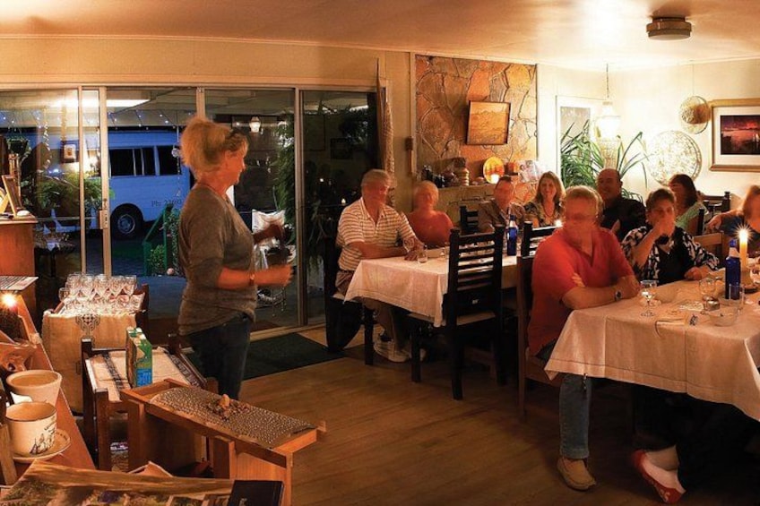 A group of people dining at an outdoor restaurant with tables and chairs. 1