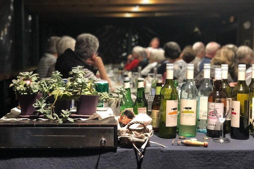 A table with wine bottles and potted plants. 4
