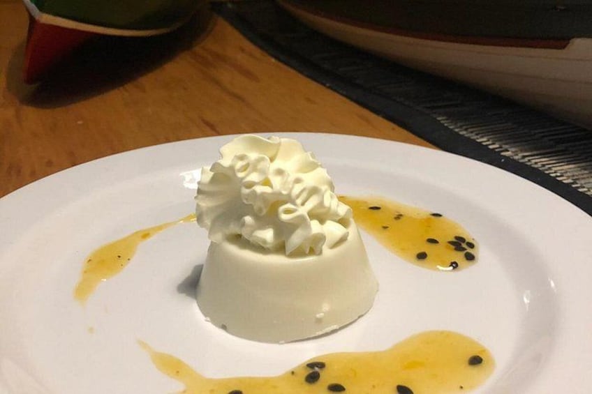 A dessert on a white plate with whipped cream and syrup. 2