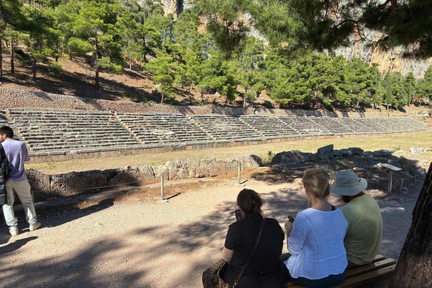 Un ancien amphithéâtre avec des gradins en pierre et quelques personnes qui l’observent. 5