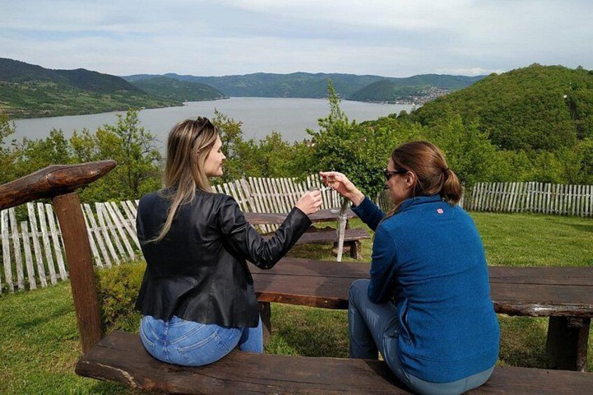 Dos personas sentadas en un banco de madera contemplando un lago con colinas al fondo. 4
