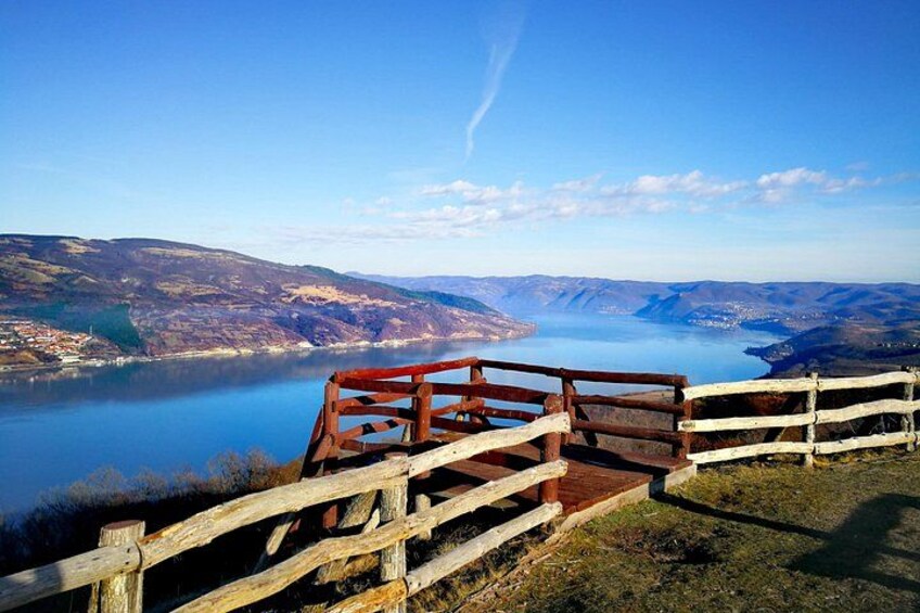 Una pasarela de madera con vistas a un lago y colinas lejanas. 2