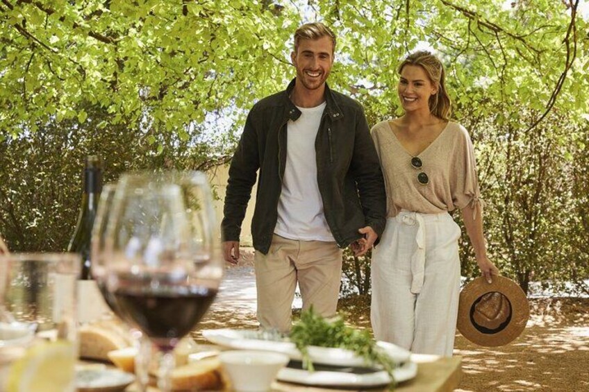 Un couple se promène sous un arbre, près d’une table dressée pour un repas. 4