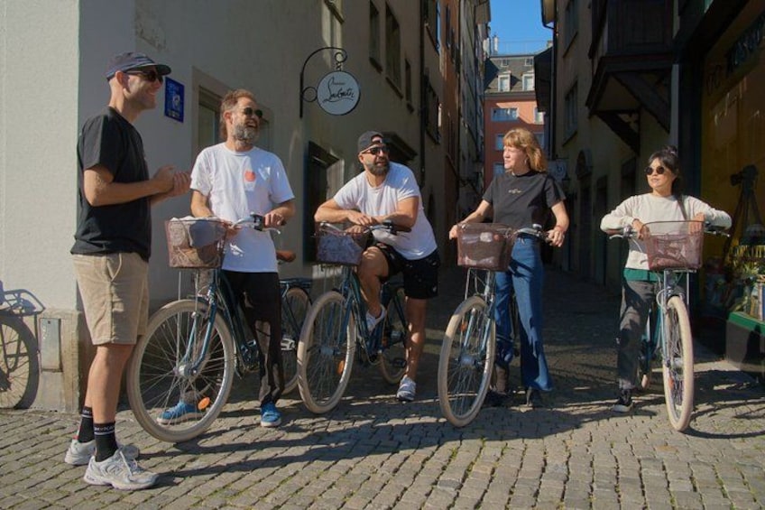 En gruppe mennesker på cykler i en bygning med brostensbelægning. 2