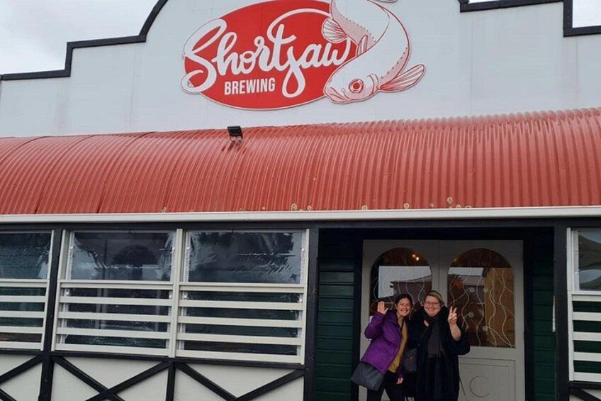Un edificio con toldo rojo y un letrero que dice 'Shorts Brewing'. 5