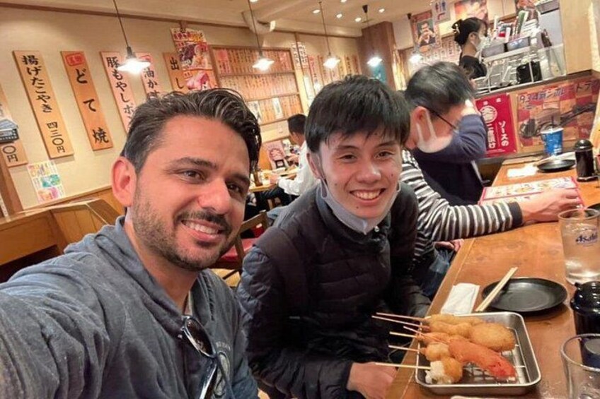 Two people sitting at a restaurant table with food and drinks. 3