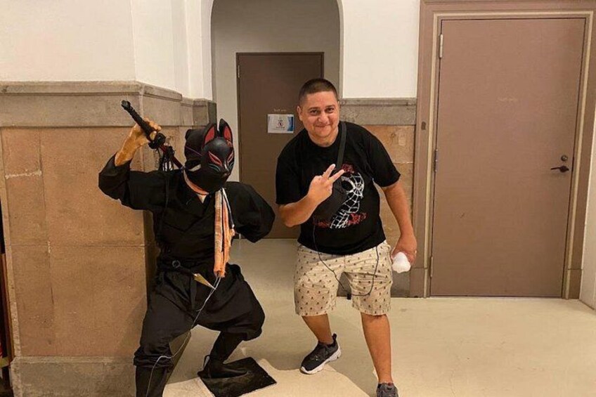 Two people in a hallway, one in a costume holding a toy gun, and the other holding a toy gun. 3