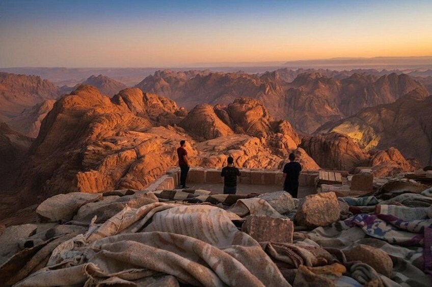 A mountainous landscape with rocky terrain and a few people standing on a ledge. 5