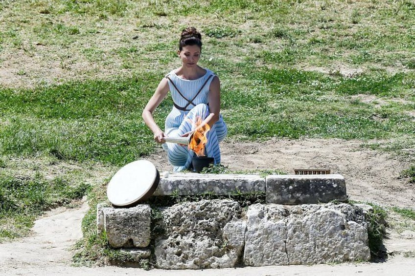 A person sitting on a stone structure in a grassy field. 3