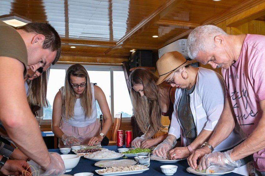 A group of people preparing food at a table with various dishes and condiments. 4