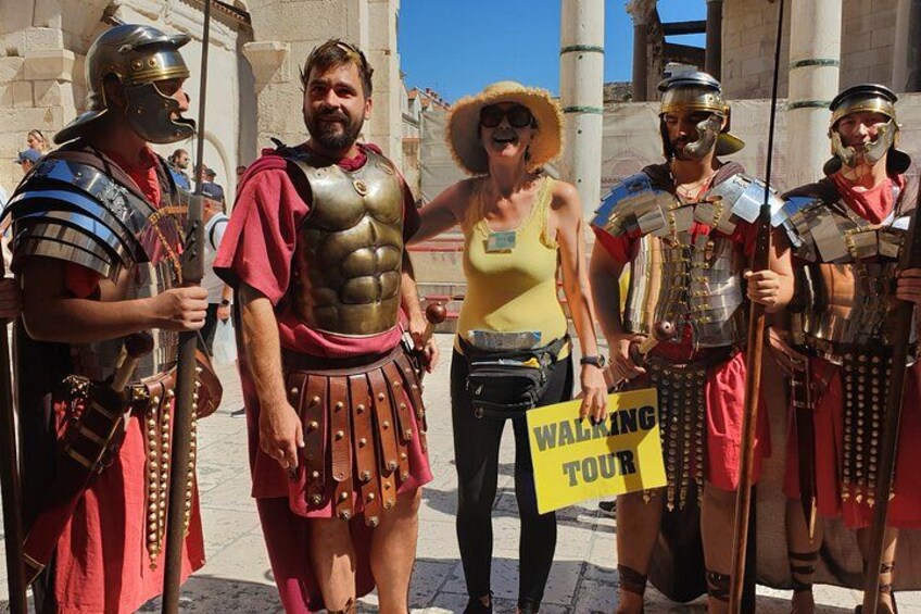 Personas con armadura romana y una mujer sosteniendo un cartel. 4