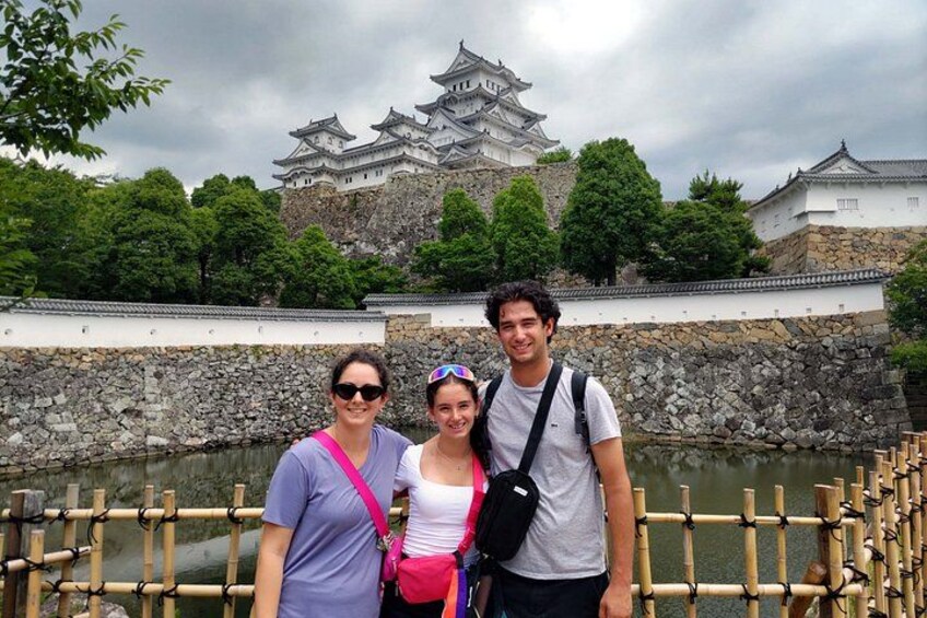 Tre personer står framför ett traditionellt japanskt slott med en vallgrav. 2