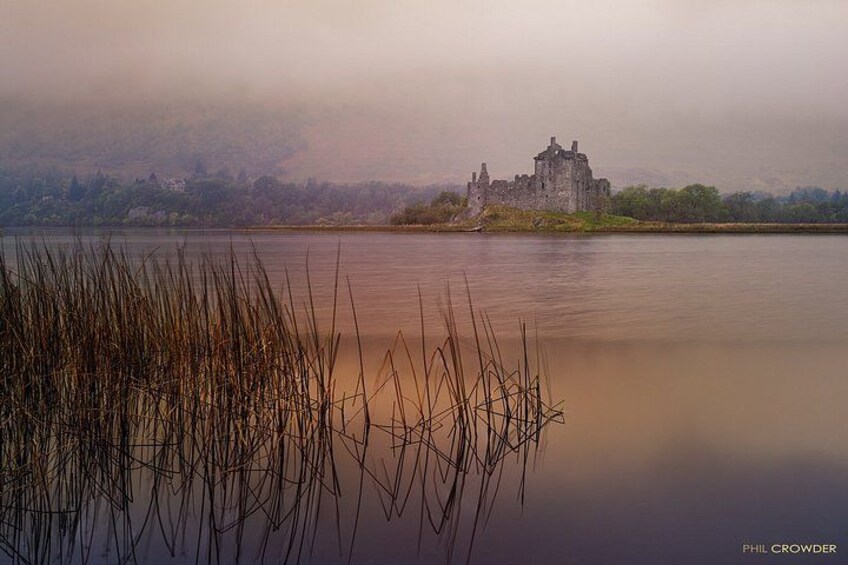 A castle on a misty lake surrounded by reeds. 3