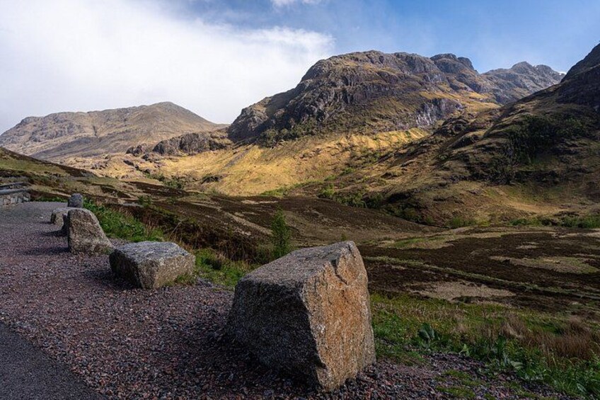 A mountainous landscape with a gravel path and large boulders. 5
