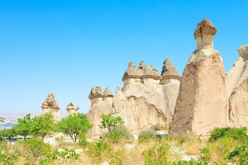 A landscape with unique rock formations, trees, and a clear sky. 3