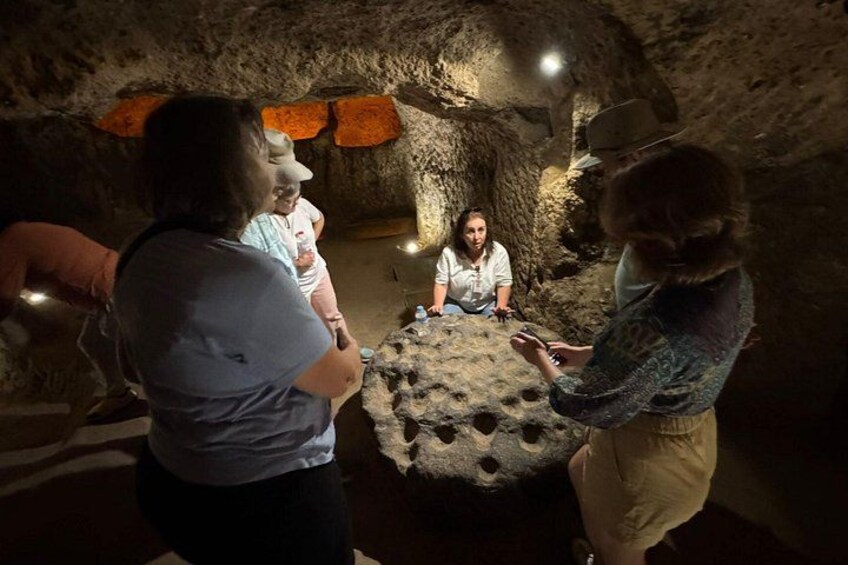 A group of people inside a cave with stalactites and a large rock formation. 2