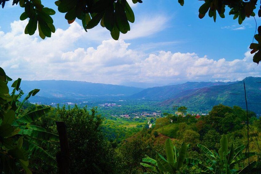 A mountainous landscape with a village in the valley, surrounded by lush greenery. 2