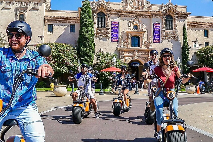 People riding Segways in front of a historic building with banners. 5
