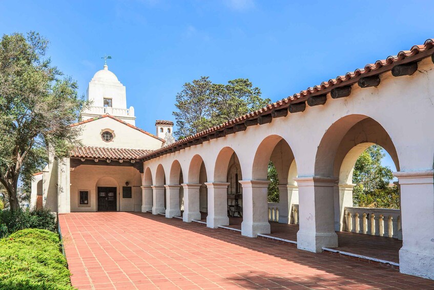 A white building with a dome and arched walkway. 3