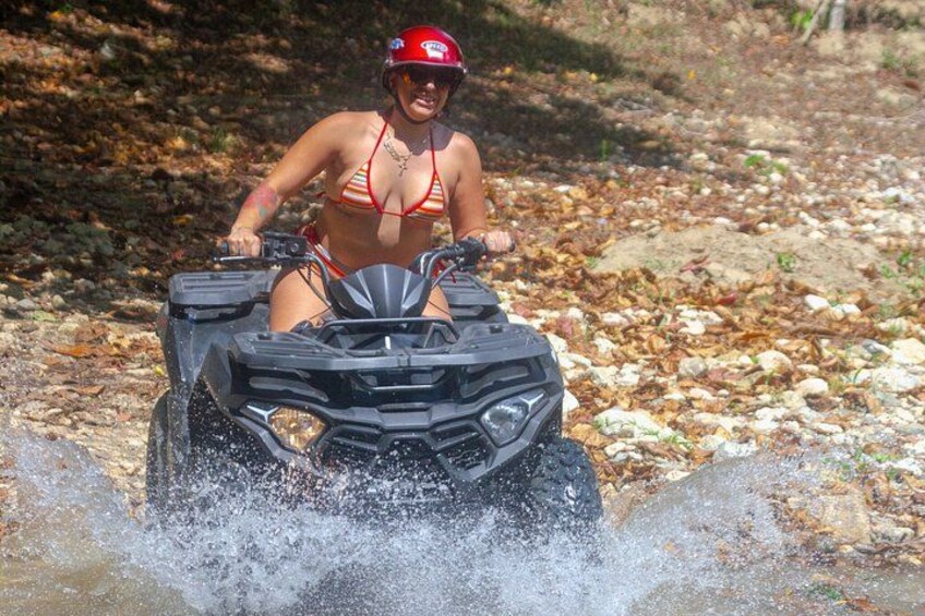 A person in a bikini riding an ATV on a rocky path. 5