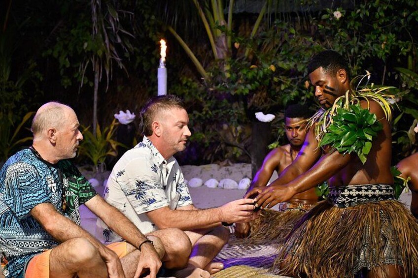 A traditional dance performance with participants in grass skirts and feathered headdresses. 3